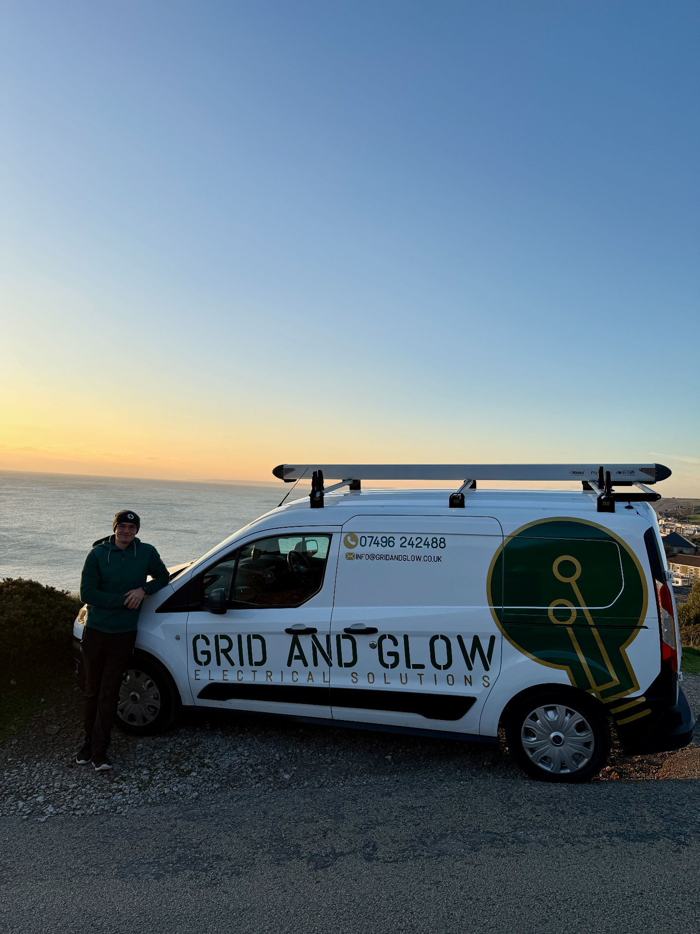 Grid and Glow van parked on the Cornish coast at sunset