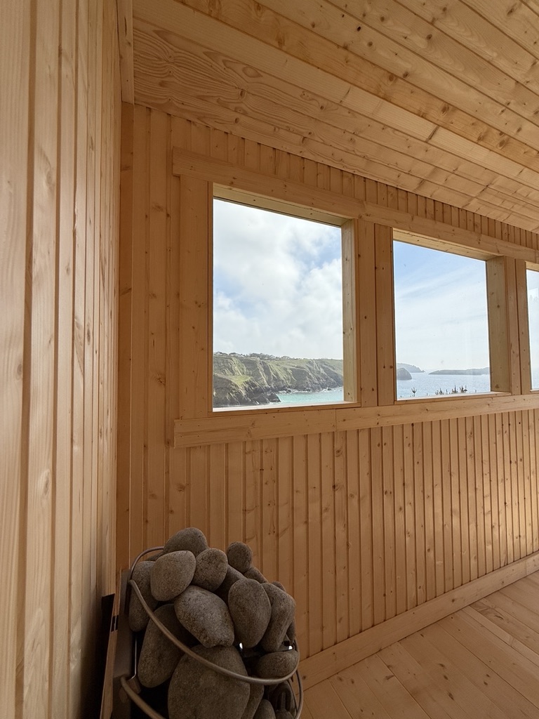 Sauna interior with feature lighting and sea view over the Cornish coast